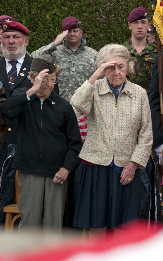 Second to right to left: Dorothy and Ellen Levitsky, World War II veterans, salute during the national anthem at a plaque dedication for them, June 4. Task Force 68, which is made up of paratroopers from across the U.S. Army, Air Force and the Parachute Regiment's 4th Battalion from London, England, attended a plaque dedication ceremony for Dorothy and Ellen Levitsky, sisters and WWII nurses who were located at a hospital in Bolleville, France, June 4. The Levitsky's were made honorary Bolleville citizens in the dedication ceremony. "We thank you for all of this, but really, we were just doing what we were told to do our jobs," said Ellen, 92 years old. Dorothy is 95 years old. Task Force 68 is in Normandy, France to commemorate the 68th anniversary of D-Day. Image: Staff Sgt. Sharilyn Wells. Caption: DVIDSHUB.