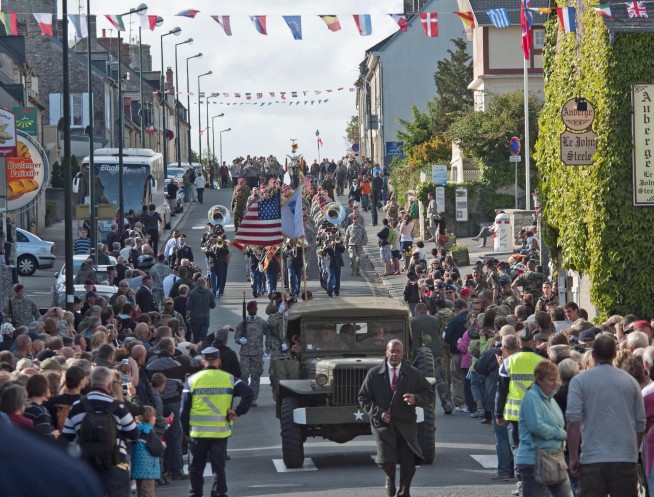 Task Force 68, which is made up of paratroopers from U.S., Germany, France, Holland, and United Kingdom, re-enacted the D-Day airborne operation on the La Fiere fields near Ste. Mere Eglise, France to commemorate the heroic acts of the WWII paratroopers who made the jump 68 years ago. After the jump, the task force marched into the town of Ste. Mere Eglise to the sounds of cheers from the locals. Task Force 68 is in Normandy, France to commemorate the 68th anniversary of D-Day. Image credit: Staff Sgt. Sharilyn Wells. Caption credit: DVIDSHUB.