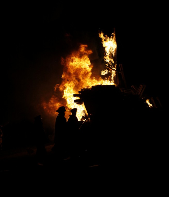 2010: Firefighters keep watch of the blaze of the bonfire tearing into the boat as thousands of Army fans cheer, "Go Army, Beat Navy" the night of Dec. 9. After a Spirit Dinner at the Cadet Mess, the Black Knights led the Corps of Cadets out of Washington Hall and onto Daly Field for a Spirit Rally and Bonfire. Addressing the crowd outside were the brigade tactical officer, Col. Mark McKearn, Army head coach Rich Ellerson and captains of the Black Knights. The game ball was handed to the captain of the West Point Marathon Team who led his teammates out of West Point for a more than 170-mile run to Philadelphia. Immediately after the bonfire, the team gathered at Battle Monument before embarking on the buses for the trip to Philadelphia to face the Navy Midshipmen at Lincoln Financial Field on Saturday. Photo by Mike Strasser. Caption: West Point Public Affairs.