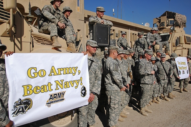 2011: Col. Ricky D. Gibbs, commander of the 4th Infantry Brigade Combat Team, 1st Inf. Div., and other Dragon Brigade Soldiers show their support for the "Black Knights" of the U.S. Military Academy at West Point by shouting out, "Go Army Beat Navy!" at Forward Operating Base Falcon in southern Baghdad, Nov. 25. Photo and caption: U.S. Army.