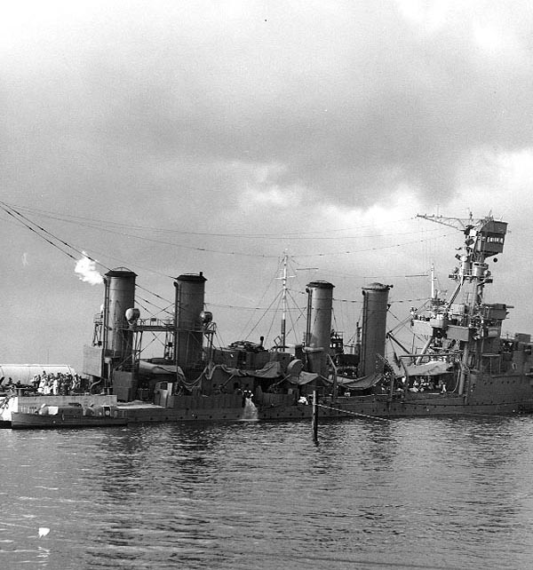 USS Raleigh (CL-7) being kept afloat by a salvage barge moored to her port side, after she had been torpedoed and damaged by a bomb during the Japanese raid. Photo & Caption: Naval History & Heritage Command.
