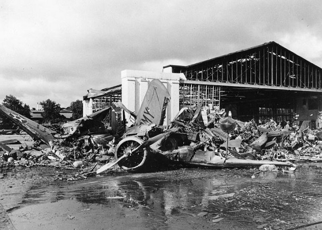 U.S. Army aircraft destroyed by Japanese raiders at Wheeler Air Field. Photographed later in the day on 7 December 1941, following the end of the attacks. Wreckage includes at least one P-40 and a twin-engine amphibian. Note the wrecked hangar in the background. Official U.S. Navy Photograph, National Archives collection. Caption: Naval History & Heritage Command.