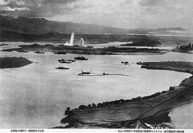 Halftone reproduction of a photograph taken from a Japanese plane during the torpedo attack on the ships moored on both sides of Ford Island. View looks about southeast, with Honolulu and Diamond Head in the right distance. Torpedoes have just struck USS West Virginia and USS Oklahoma on the far side of Ford Island. On the near side of the island, toward the left, USS Utah and USS Raleigh have already been torpedoed. Fires are burning at the seaplane base, at the right end of Ford Island. Across the channel from the seaplane base, smoke along 1010 Dock indicates that USS Helena has also been torpedoed. Japanese inscriptions at the bottom indicate that this view was published by Osaka University. Photo and Caption: Naval History & Heritage Command.