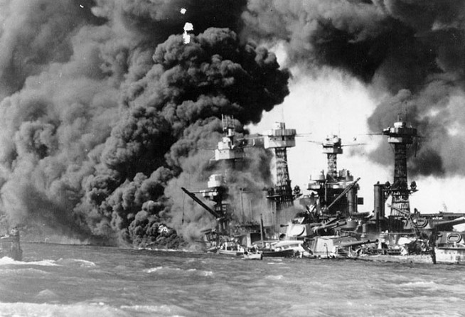 USS West Virginia (BB-48) afire forward, immediately after the Japanese air attack. USS Tennessee (BB-43) is on the sunken battleship's opposite side. Photo and Caption: Naval History & Heritage Command.