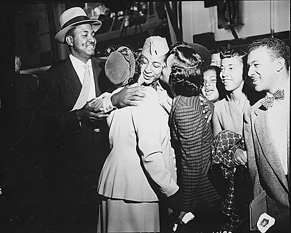 1st Lieutenant. Alvin Anderson, one of the many repatriated Prisoners of War to return home aboard the USNS Marine Phoenix, embracing his mother and sister as other members of his family look on. Fort Mason, California, September 14, 1953. Credit: National Archives.