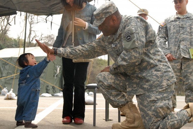 Maj. Gen. Michael T. Harrison, the commanding officer for U.S. Army Japan I-Corps (Forward), high-fives a toddler, displaced by the Great East Earthquake in Matsushima, Japan, April 15, 2011. Harrison visited schools, train stations, shower points and shelters for displaced citizens to reaffirm the U.S. military's commitment to the helping the Japanese people. Credit: Spc. Cody Thompson, DVIDSHUB.
