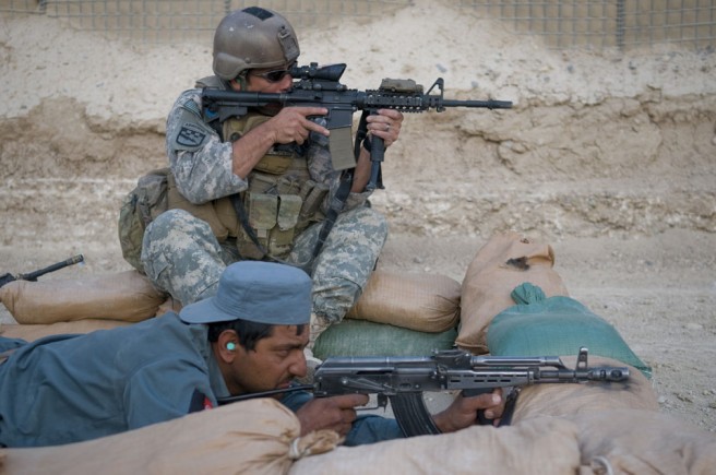Army Sgt. Anthony Valdez, infantryman, Charlie Company, 1st Squadron, 38th Cavalry Regiment, 525th Battlefield Surveillance Brigade, and an Afghan Customs Police officer from the Kandahar inland customs depot, aim their weapons at paper targets during reflexive-fire training at Forward Operating Base Walton, Afghanistan May 27, 2011. Valdez, a Fayetteville, N.C., native based out of Fort Bragg, N.C. told the ACP officers to rely on their instinctive reactions while engaging close target silhouettes. Credit: Senior Airman Jessica Lockoski, DVIDSHUB.