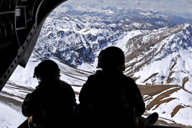 Two crew members keep watch on the rear ramp of a CH-47 Chinook while flying over the mountains in the Khas Uruzgan district of Afghanistan on March 16, 2013. U.S. Army photo by Sgt. Jessi Ann McCormick