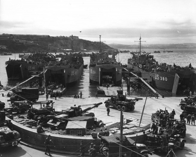 In preparation for the invasion, artillery equipment is loaded aboard LCTS at an English port. Brixham, England. 1 June 1944. Image and caption credit: U.S. Army Center of Military History.