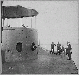 The Original Monitor after her Fight with the Merrimac. Near the port-hole can be seen the dents made by the heavy steel-pointed shot from the guns of the Merrimac. Credit: National Archives.