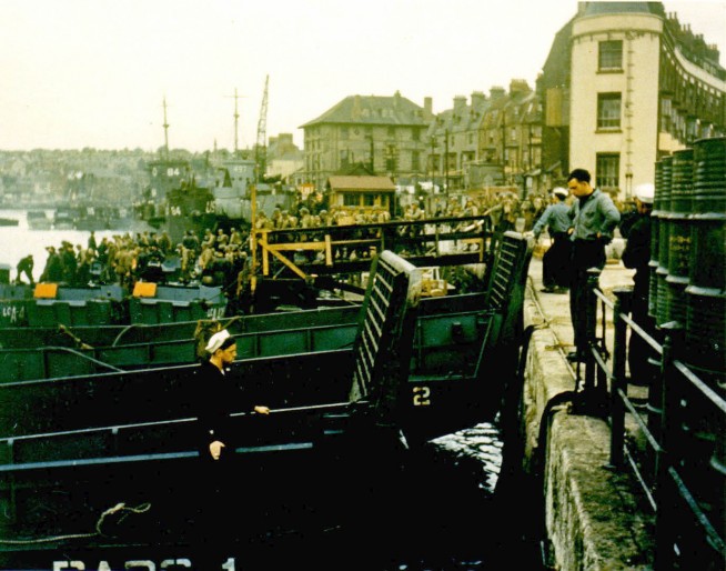 American troops load onto landing craft at a port in Britain from where they will shove off for the invasion of Europe on D-Day. Undated - June 1944. Image and caption credit: Center of Military History.