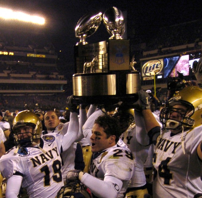 Philadelphia, Pa. (Dec. 3, 2005) – U.S. Naval Academy football players carry the Commander-in-Chief's Trophy off the field following a 42-23 victory over the Black Knights of Army. This was the 106th Army vs. Navy Football game, held for the third consecutive year at Lincoln Financial Field. U.S. Navy photo by Damon J. Moritz. Caption: U.S. Navy. 