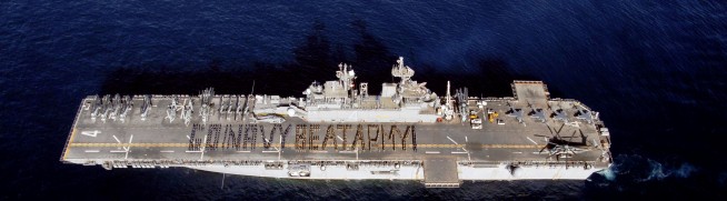 2008: Sailors and Marines aboard the amphibious assault ship USS Boxer spell out "Go Navy, Beat Army!" on the flight deck to cheer on the midshipmen in the upcoming 109th Army-Navy college football game. Photo: Petty Officer 2nd Class Jon Rasmussen. Caption: DVIDSHUB. 