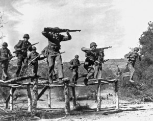 Marirne Raiders run through an obstacle course as they prepare to go to war. They are armed with an assortment of weapons, including the M1 Garand rifle, Thompson submachine gun, and Browning automatic rifle (BAR). Caption credit: MARSOC by Fred Pushies. Image credit: USMC PHOTO.