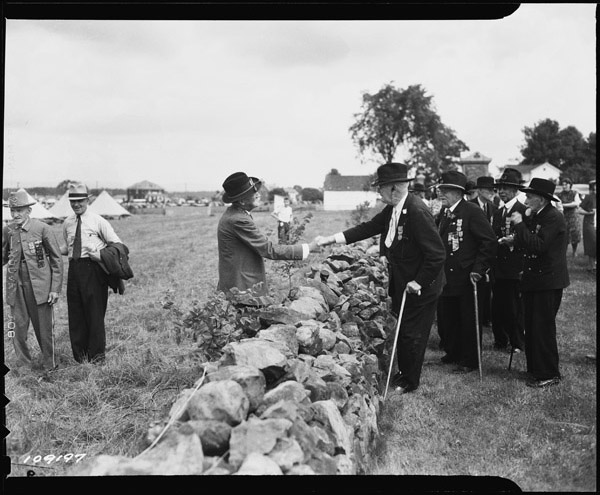 Union and Confederate Veterans Shaking Hands Across the Stone Wall at the 1938 “Blue and Gray Reunion” at Gettysburg, 1938. Credit: National Archives
