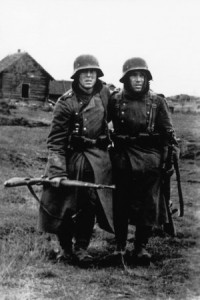 A pair of German soldiers outside a Russian village. The weather conditions are given away by the soldiers’ clothing – greatcoats over their normal uniforms and the soldier on the right has a balaclava under his helmet. The expressions on their faces suggest they must have just been in combat and the one on the left seems to be injured. Image credit: Nik Cornish Library. Caption credit: Stalingrad 1942 by Peter Antill.